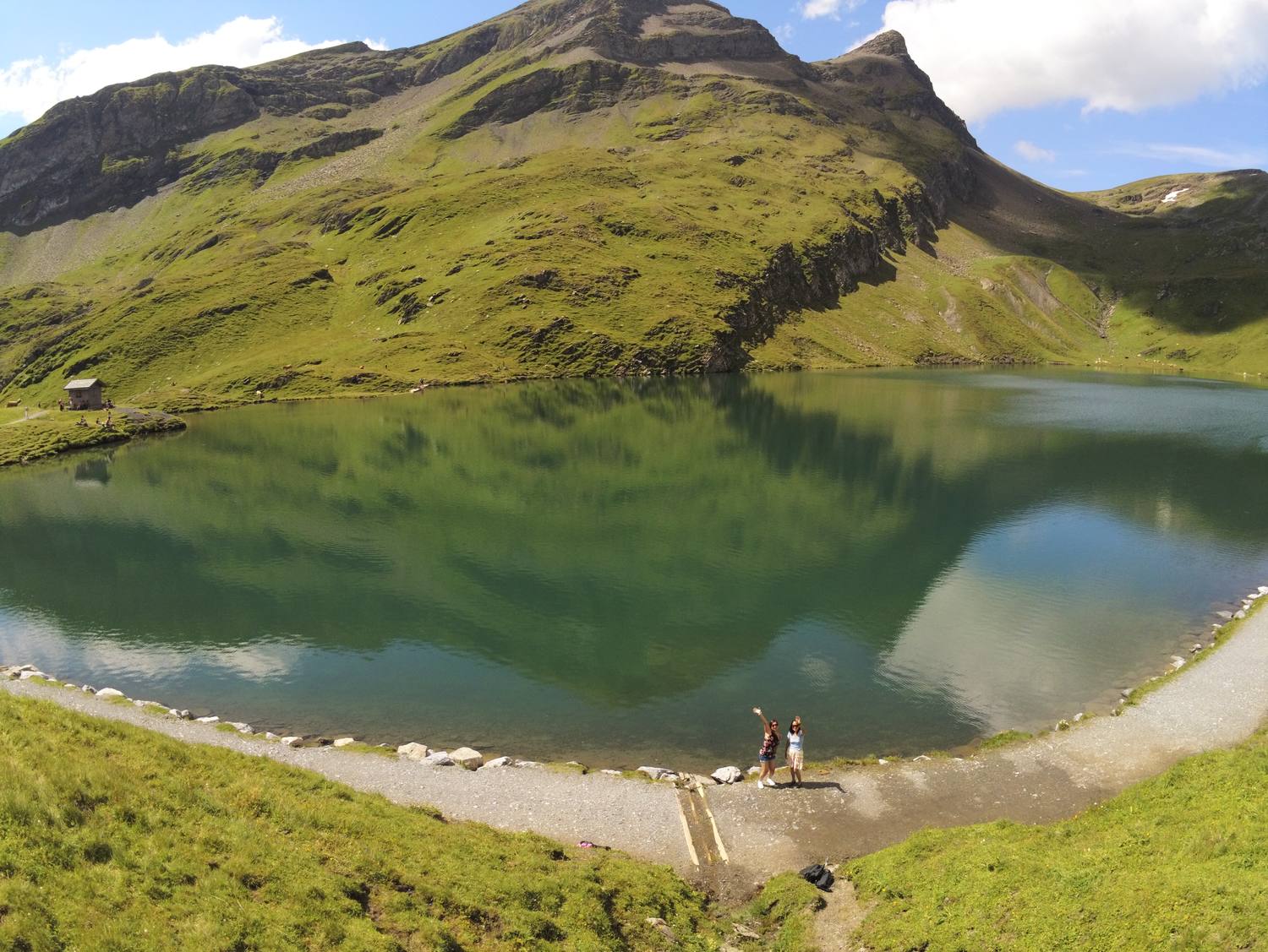 Two hikers on the shore of the Bachalpsee above Grindelwald