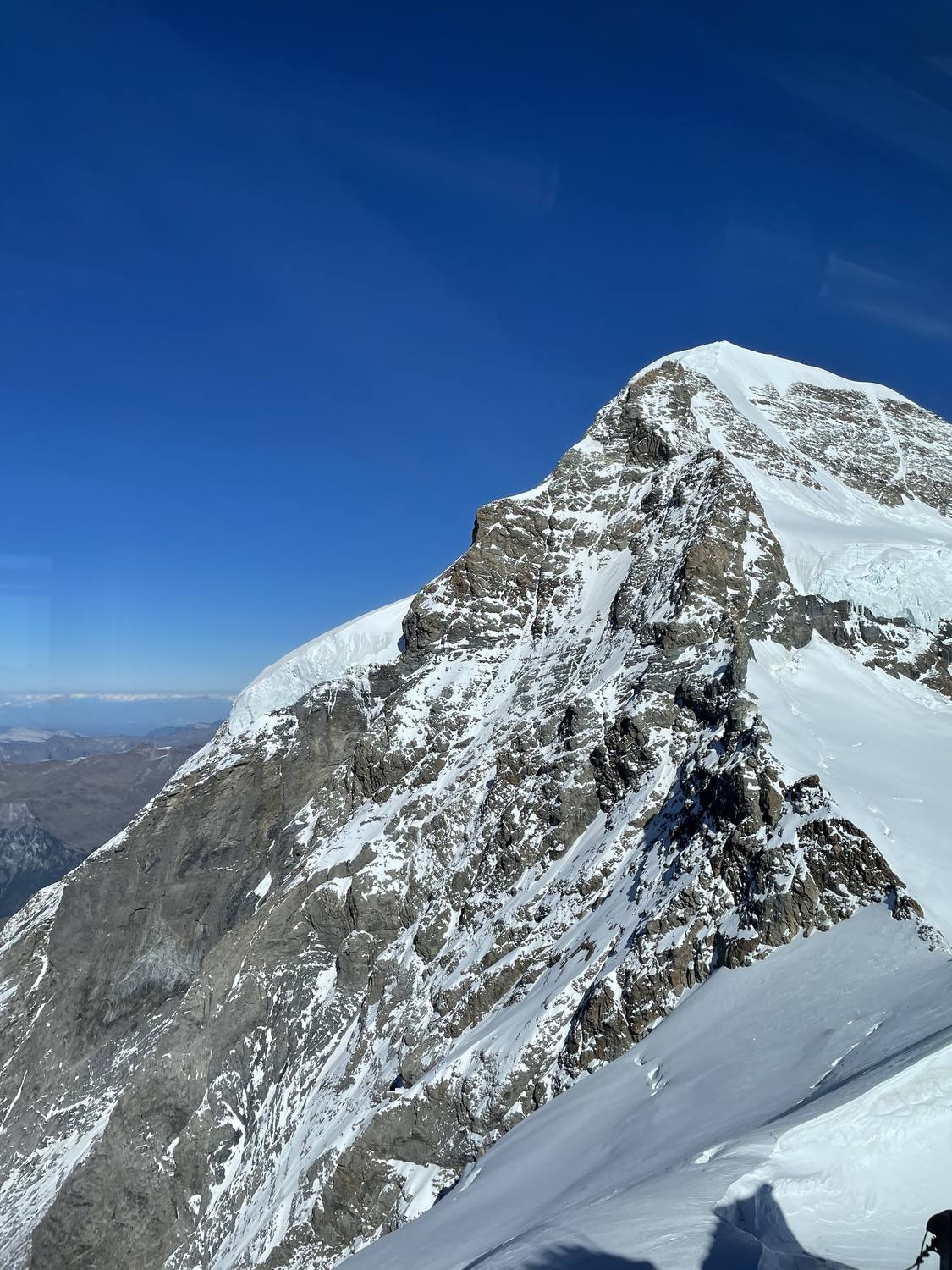 The snow-covered summit of the Jungfrau against a deep blue sky
