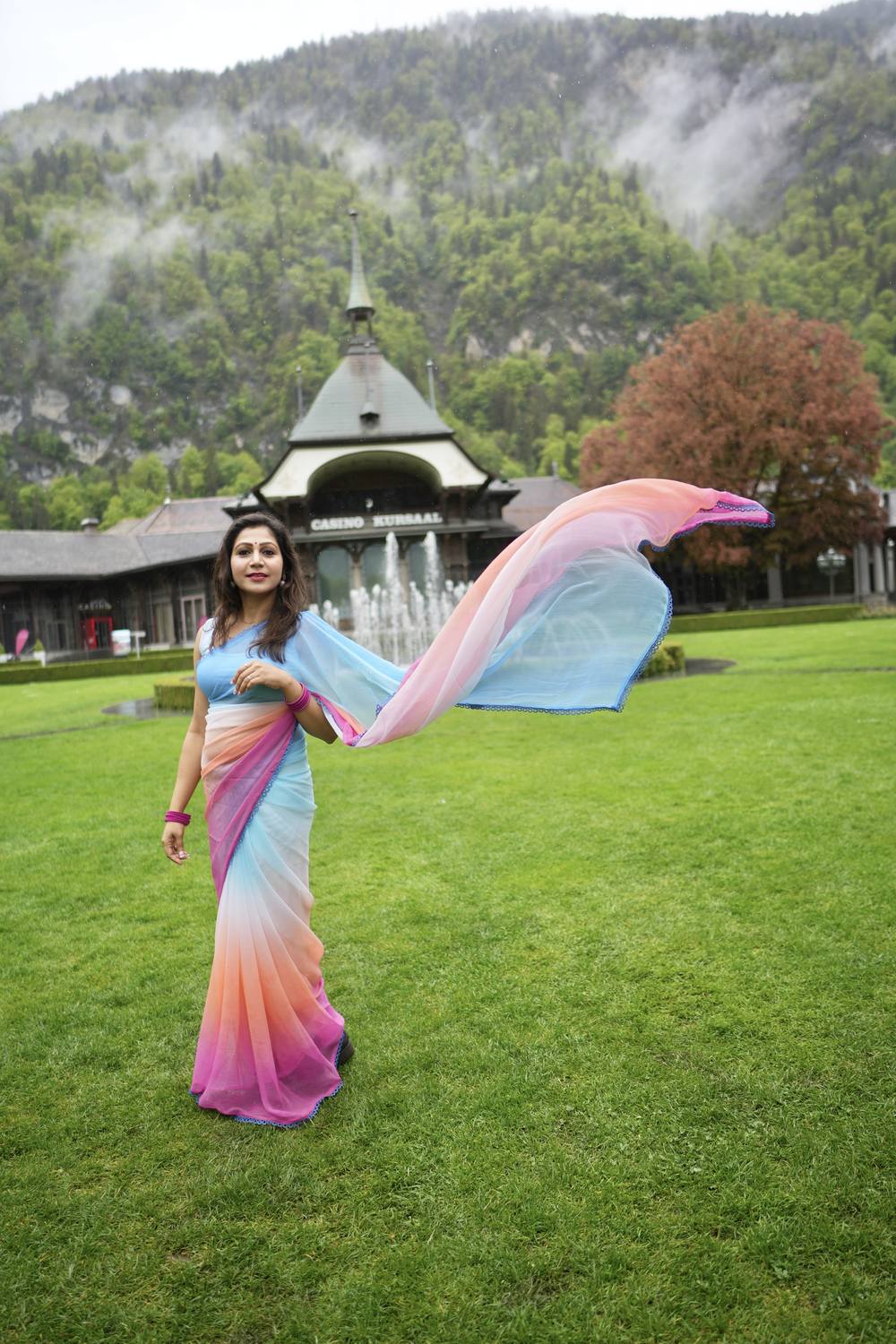 A guest with a flowing scarf on the Hoehematte lawn in front of the Kursaal in Interlaken