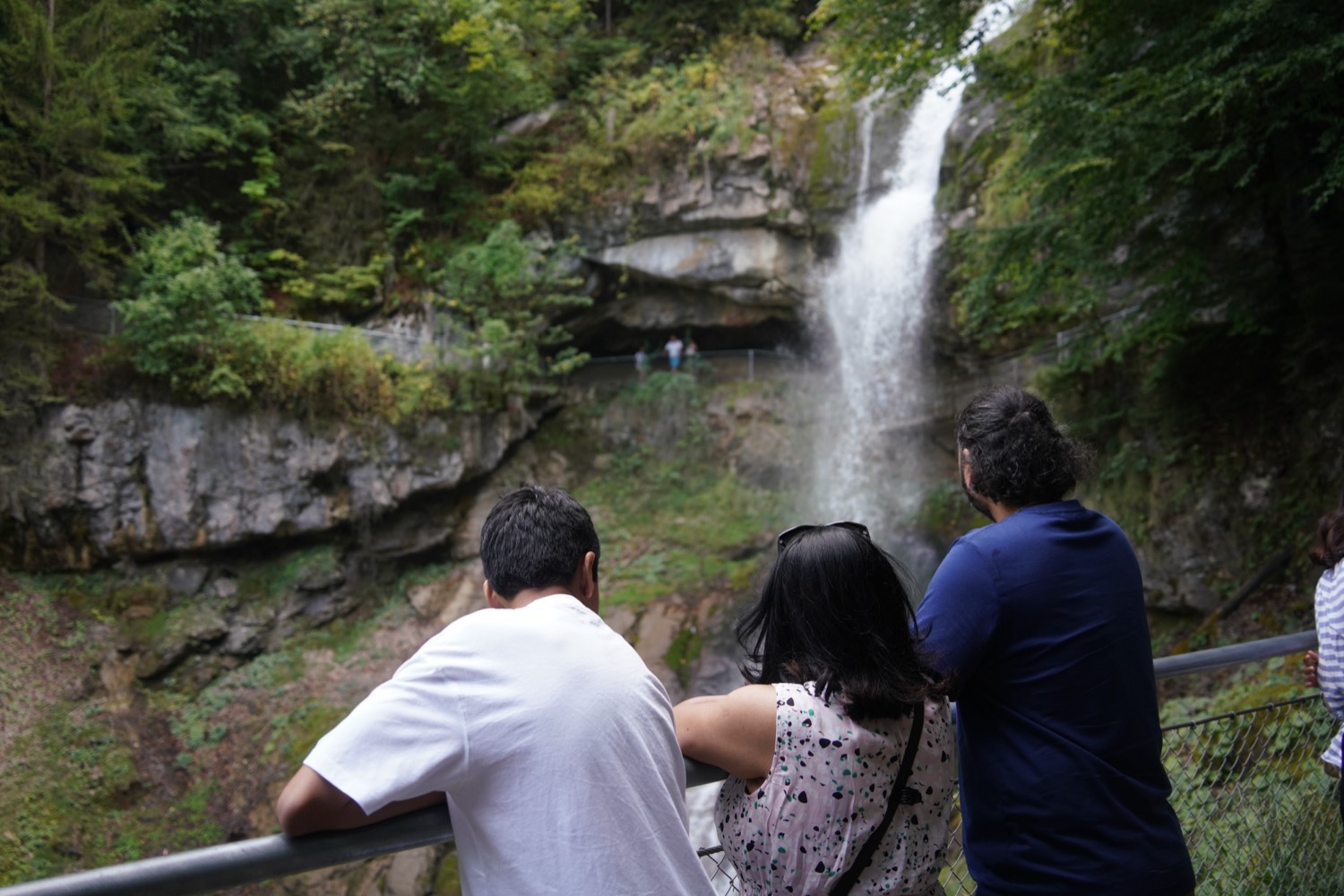 A family looking up at the Giessbach Falls above Lake Brienz