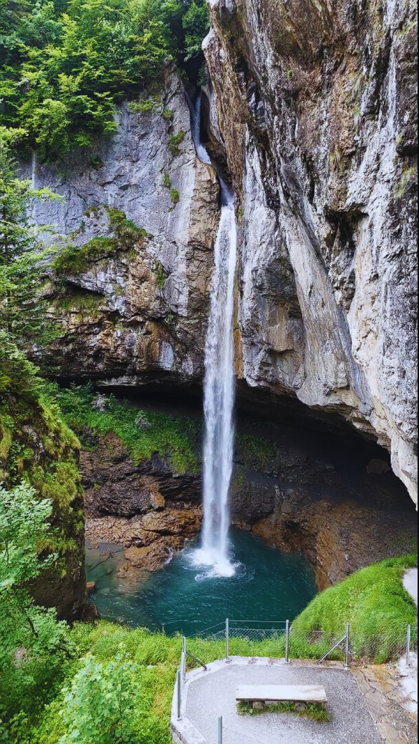 The lower Giessbach fall dropping into a turquoise pool inside a rock amphitheatre