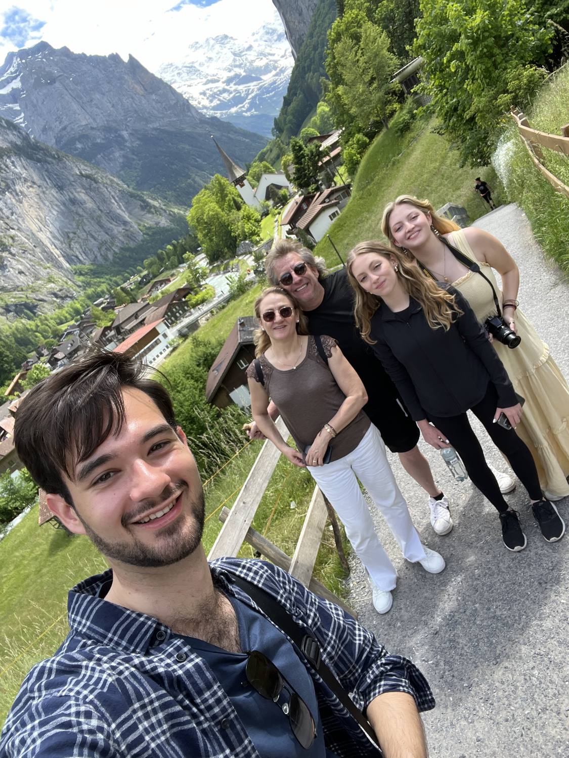 Guests and their guide in a selfie above Lauterbrunnen, the valley behind them