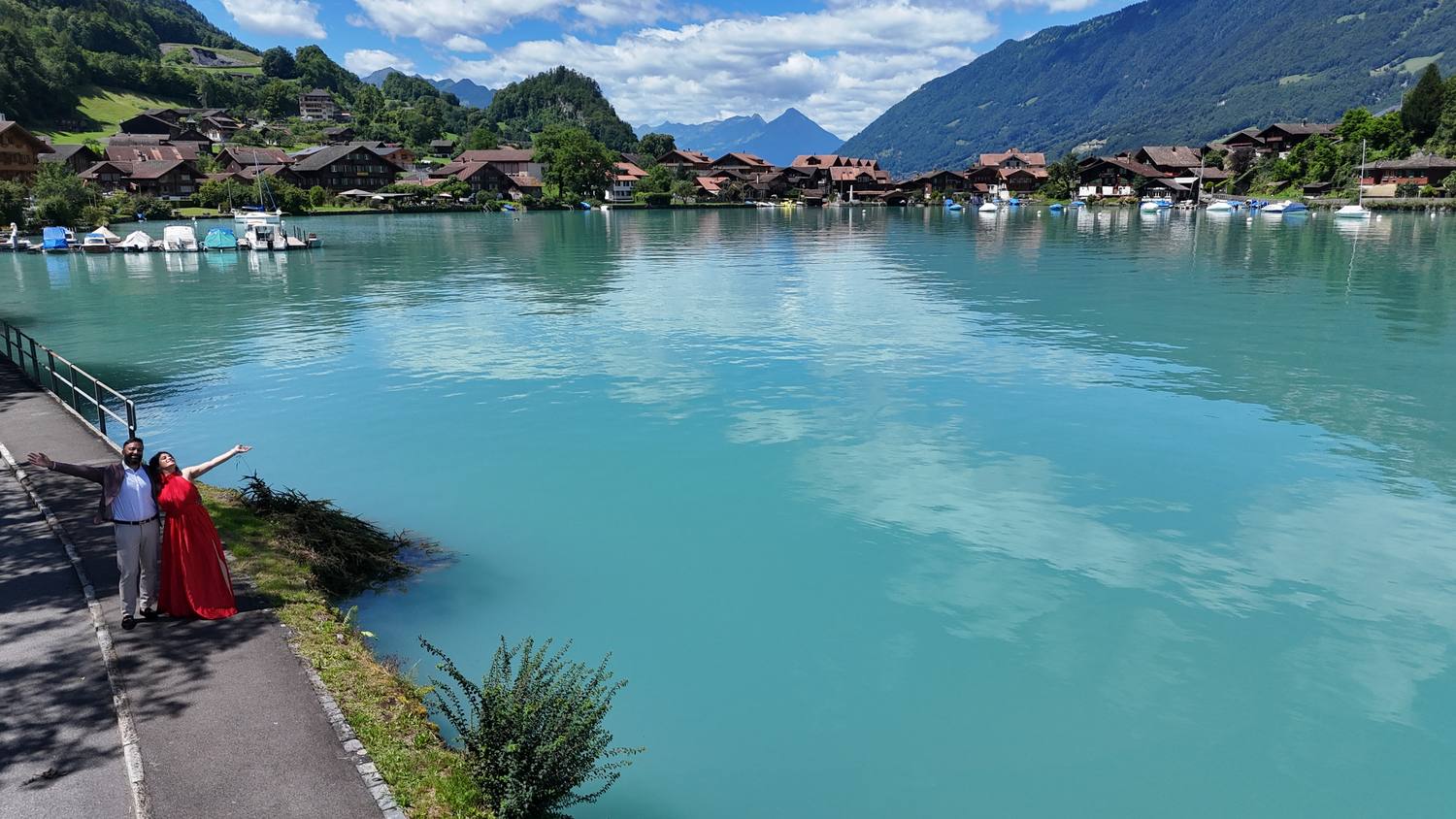 Two guests at the turquoise water of Lake Brienz by the boat harbour of Iseltwald