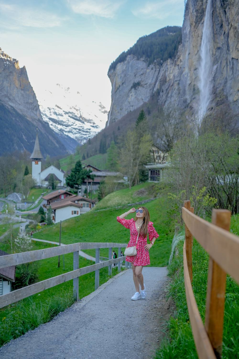 A guest on the path above Lauterbrunnen, with the village church and the Staubbach Falls behind