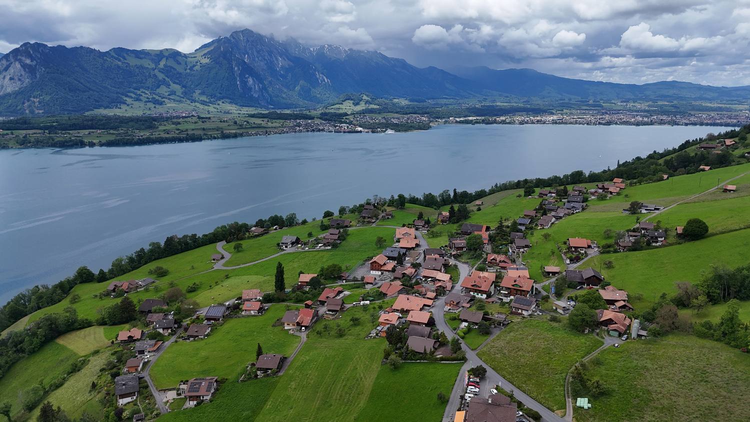 The chalets of Sigriswil on their terrace above Lake Thun, the Niesen across the water