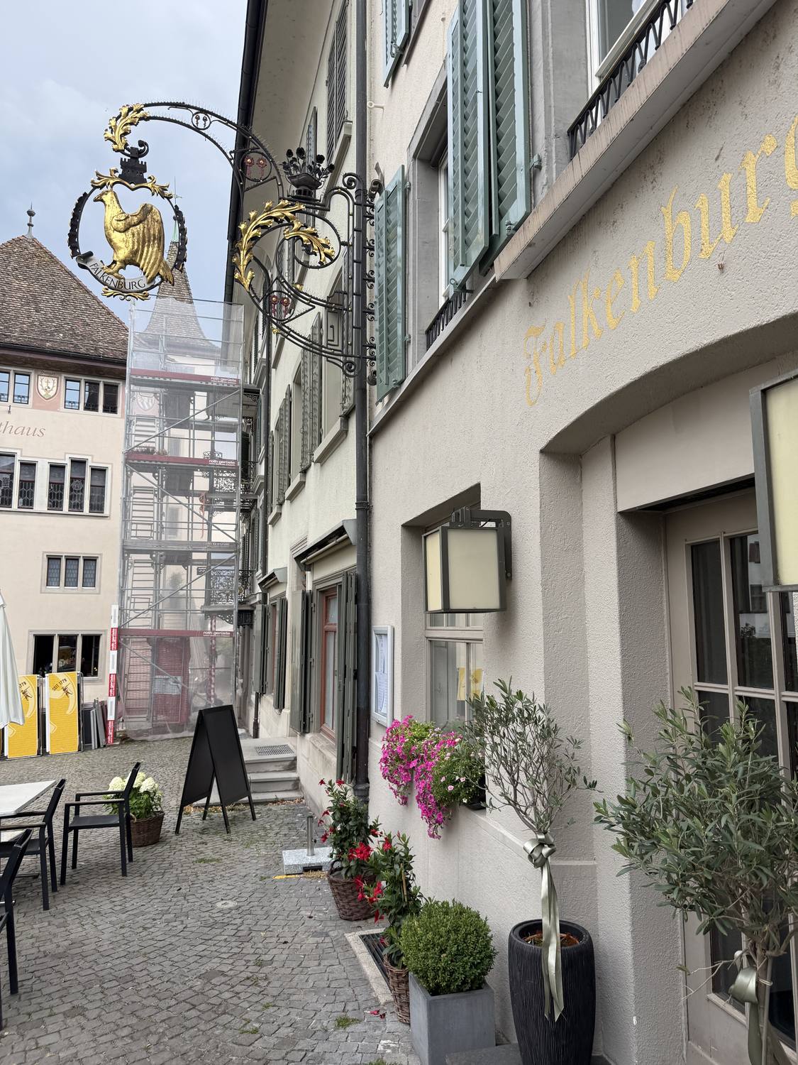 A quiet lane in Rapperswil old town with a gilded wrought-iron inn sign