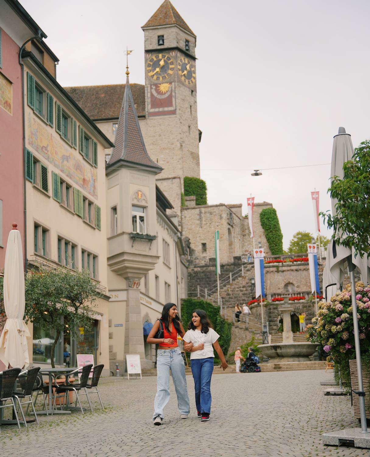 Two guests on the main square in Rapperswil below the clock tower and the castle