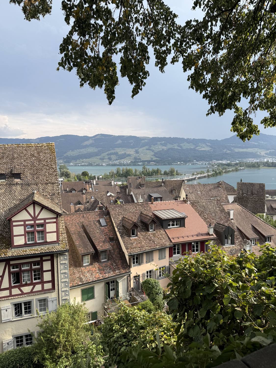 The tiled roofs of Rapperswil old town with Lake Zurich and the causeway behind