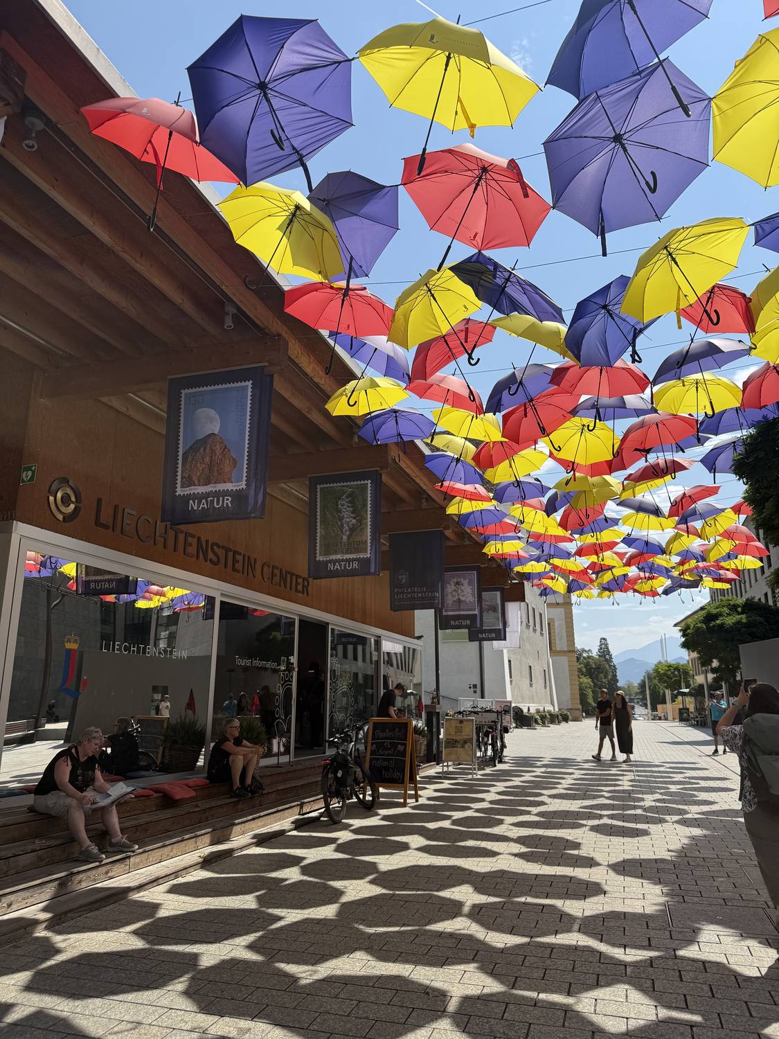 The Staedtle in Vaduz under a canopy of coloured umbrellas, with the Liechtenstein Center behind
