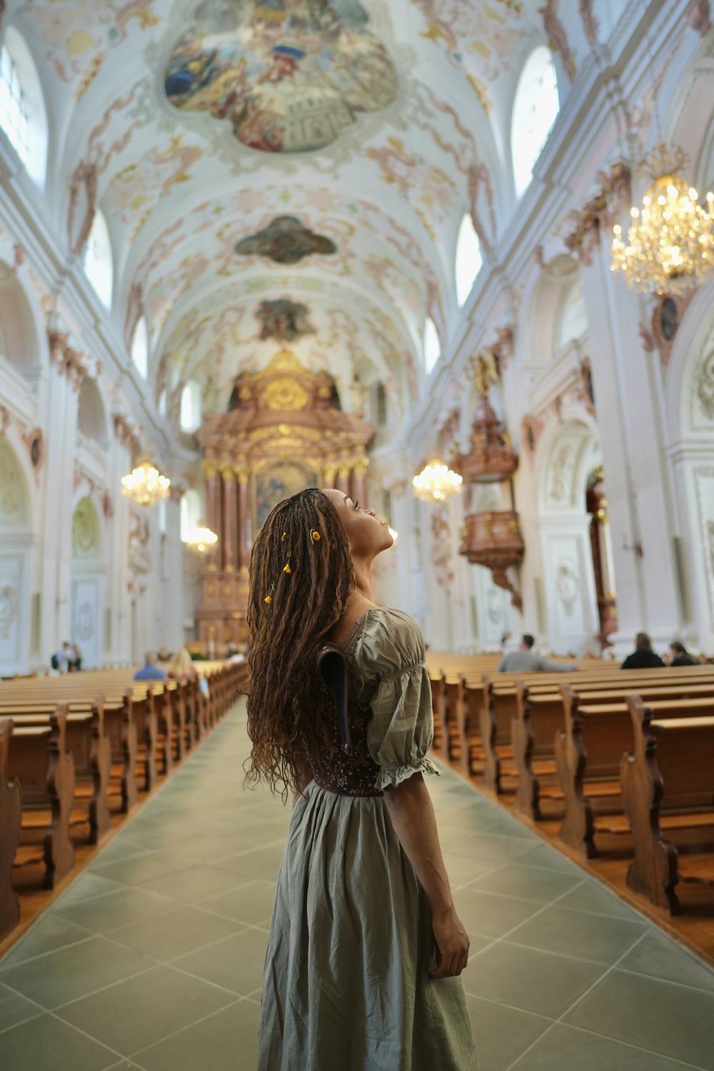 A guest looking up at the painted ceiling inside the Jesuit Church in Lucerne