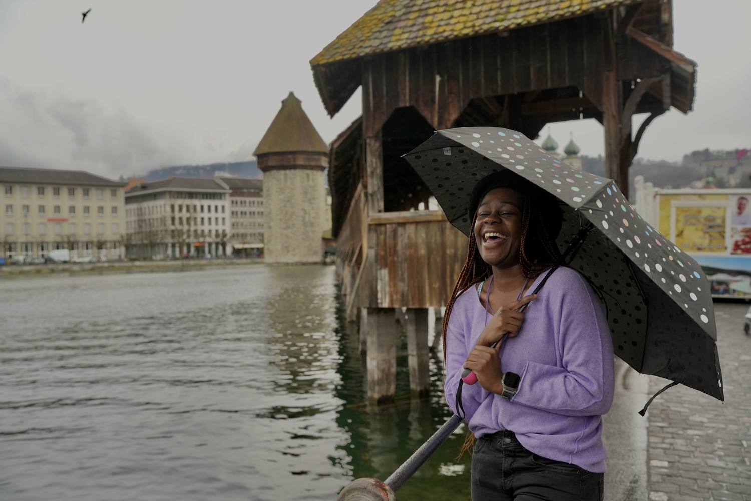 A guest with an umbrella at the Chapel Bridge in Lucerne on a rainy day