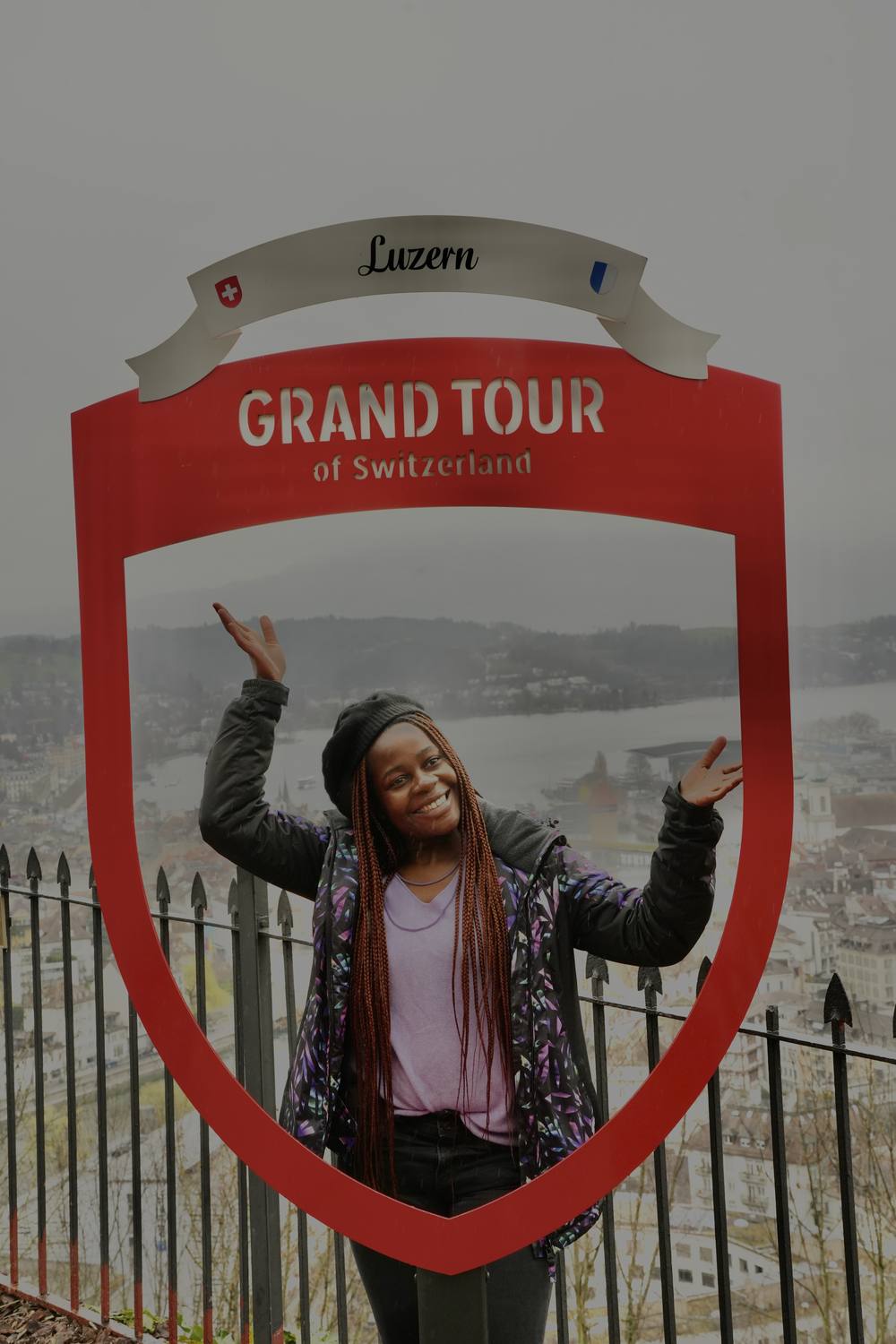 A guest posing in the Grand Tour of Switzerland photo frame above Lucerne, with the lake behind