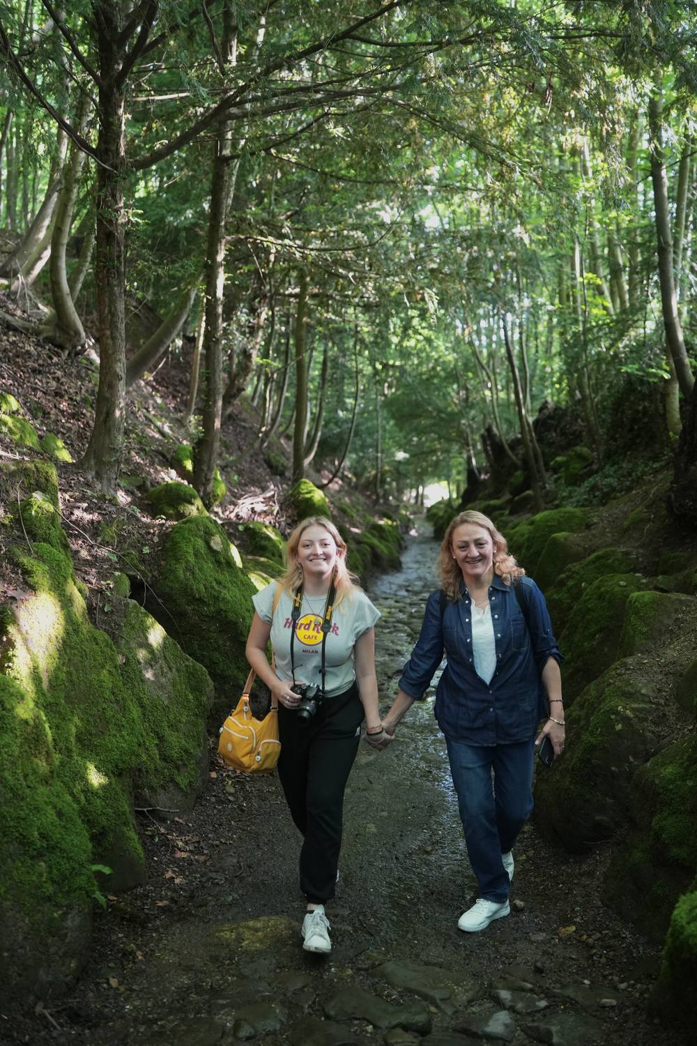 Two guests walking hand in hand through the mossy Hohle Gasse near Küssnacht