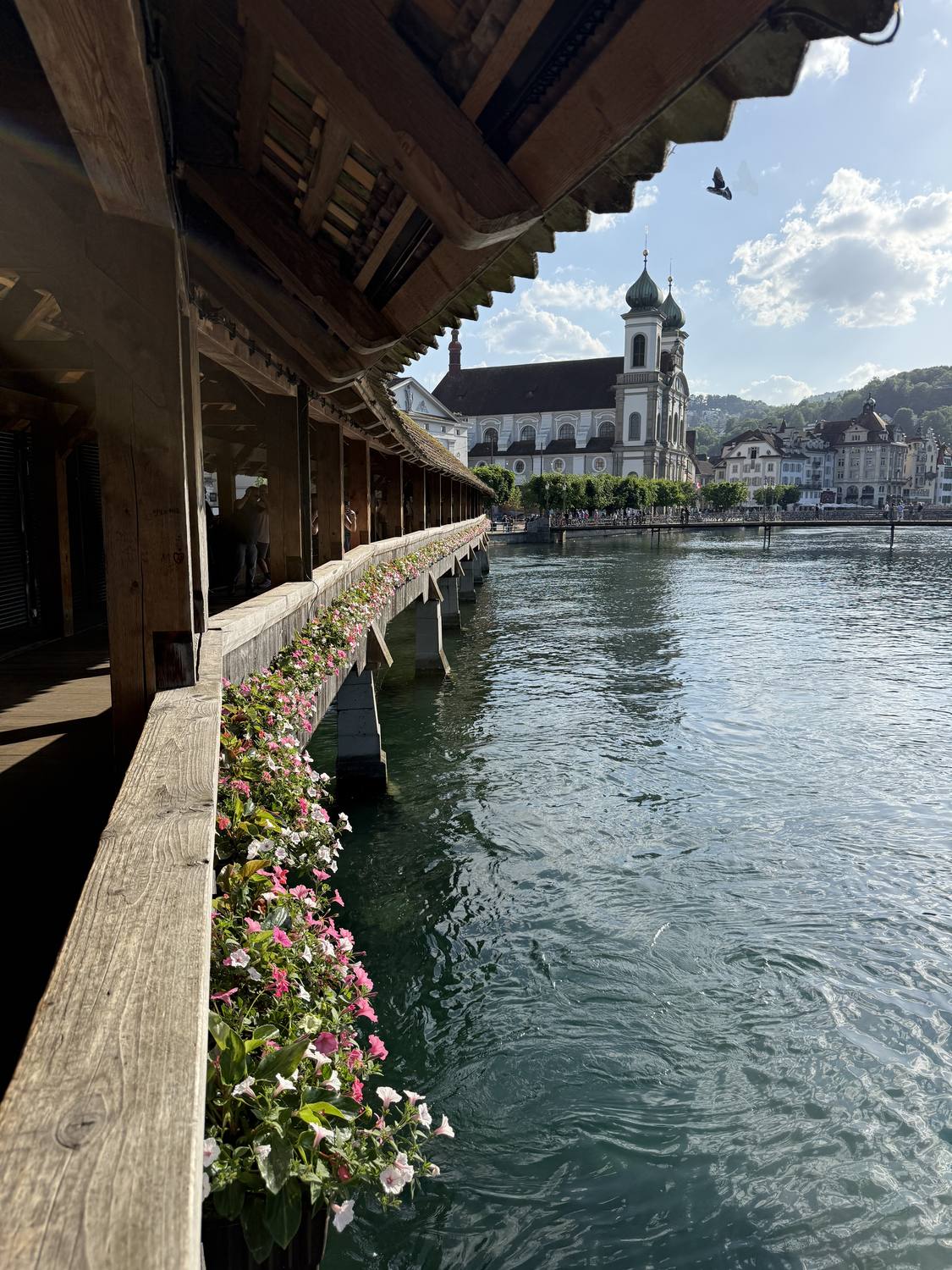 Looking along the flower boxes of Lucerne's Chapel Bridge towards the Jesuit Church