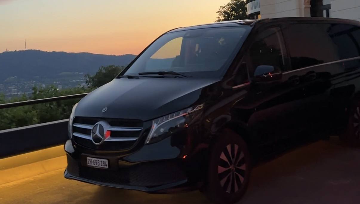 Our black Mercedes-Benz V-Class at dusk above Zurich, with the Uetliberg on the horizon