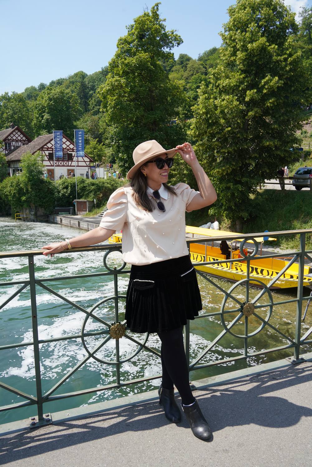 A guest on the bridge above the Rhine Falls boat landing, the yellow tour boats moored behind her