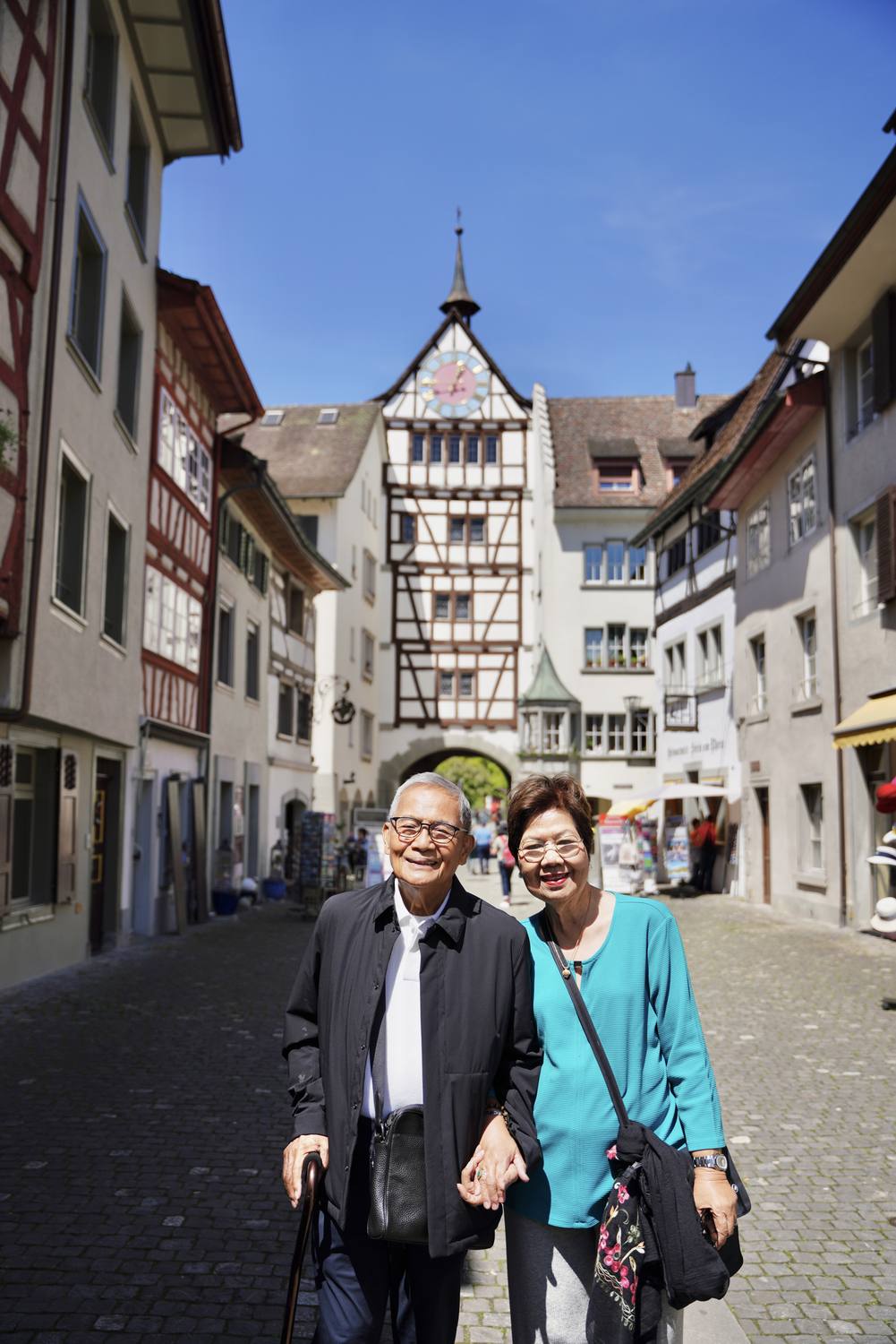 A couple in the old town of Stein am Rhein, in front of the half-timbered Untertor gate tower