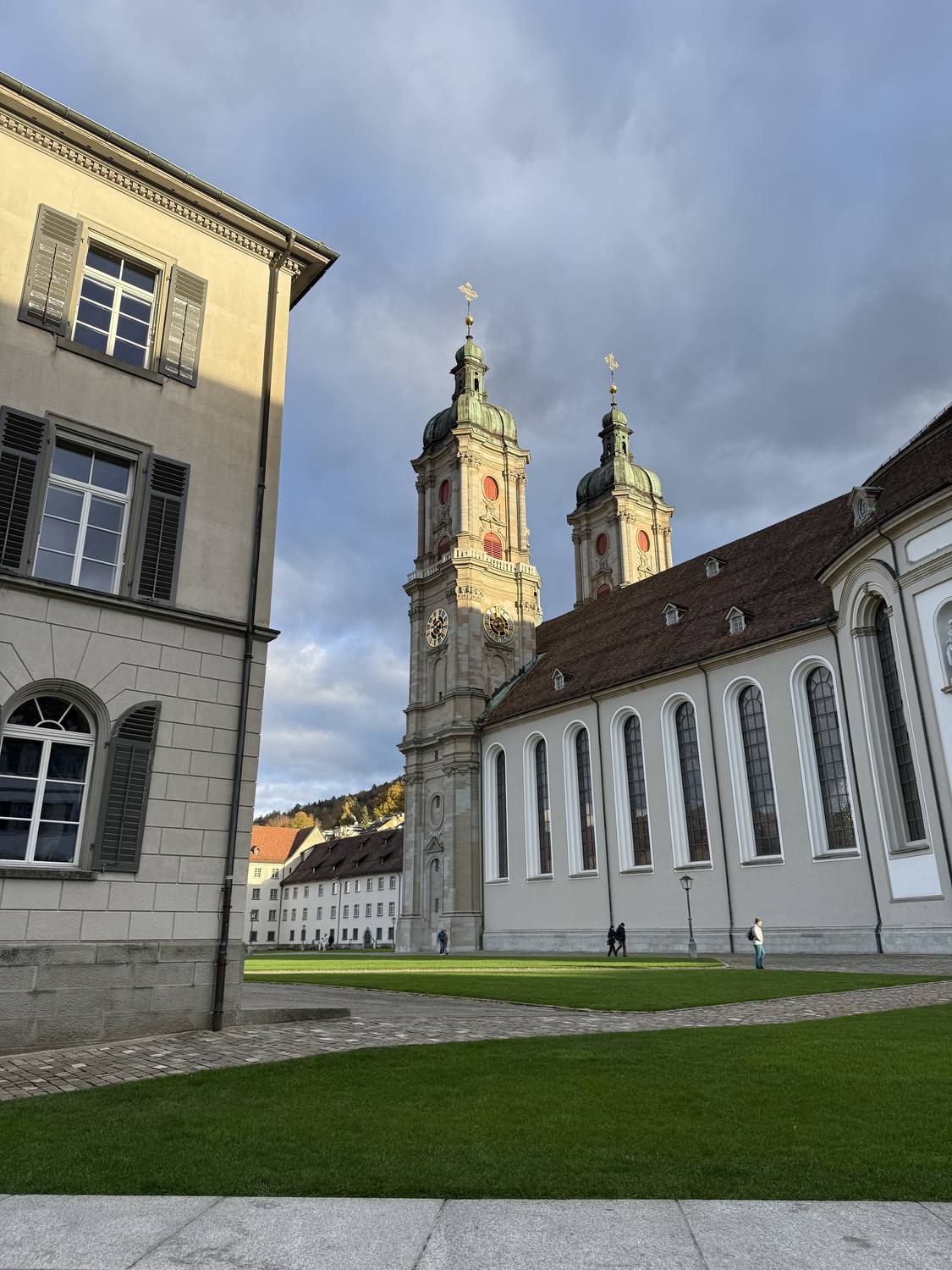 The twin towers of the Abbey of St. Gall catching the last light above the abbey courtyard