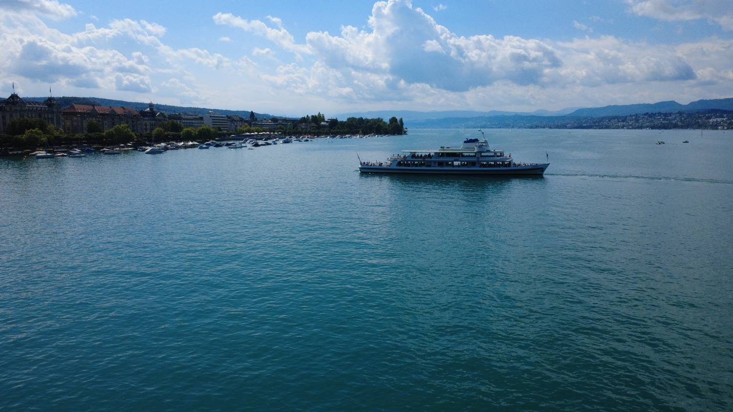 A lake boat off the Zurich promenade, the city and the Alps beyond