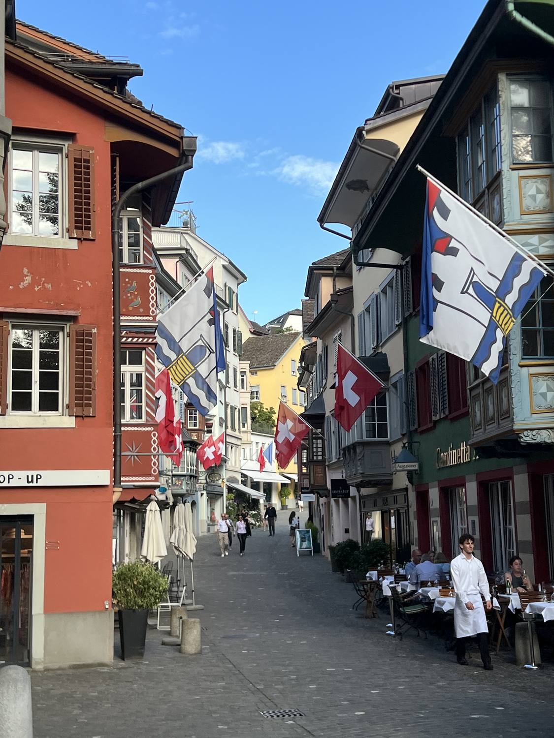A Niederdorf lane hung with Swiss and Zurich flags above the restaurant tables