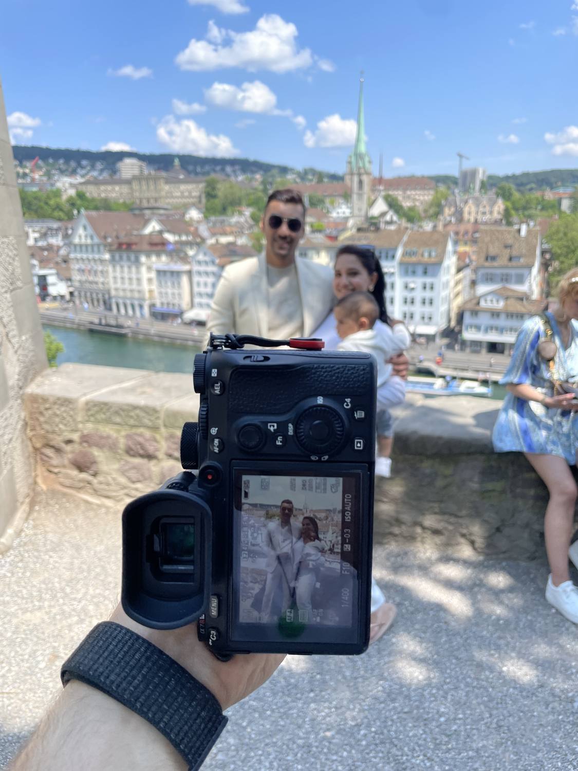 Behind the scenes on the Lindenhof in Zurich: the camera display shows a family, the old town behind