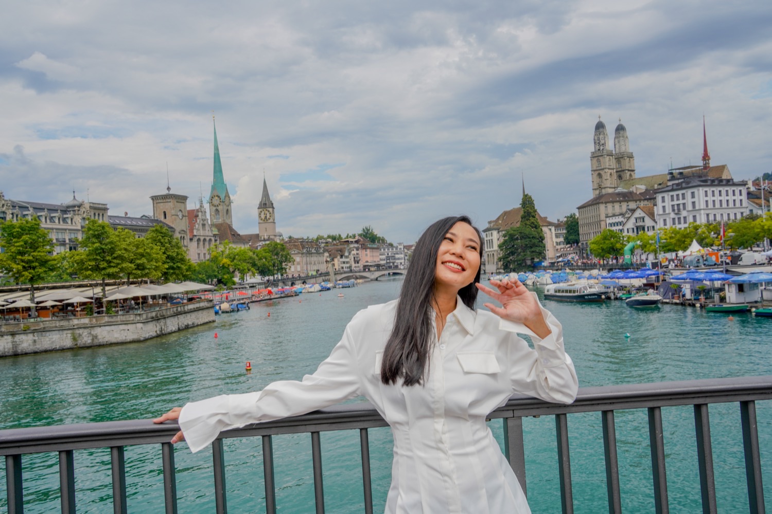 A guest walking along the Limmat in Zurich with the Grossmünster and Fraumünster in view