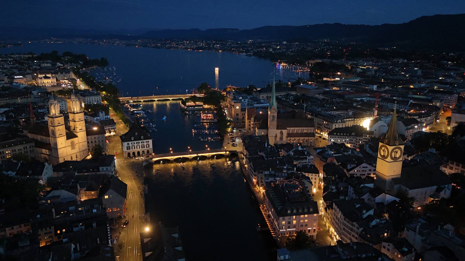 Zurich's old town and the Limmat at dusk, with the lights coming on along the quays